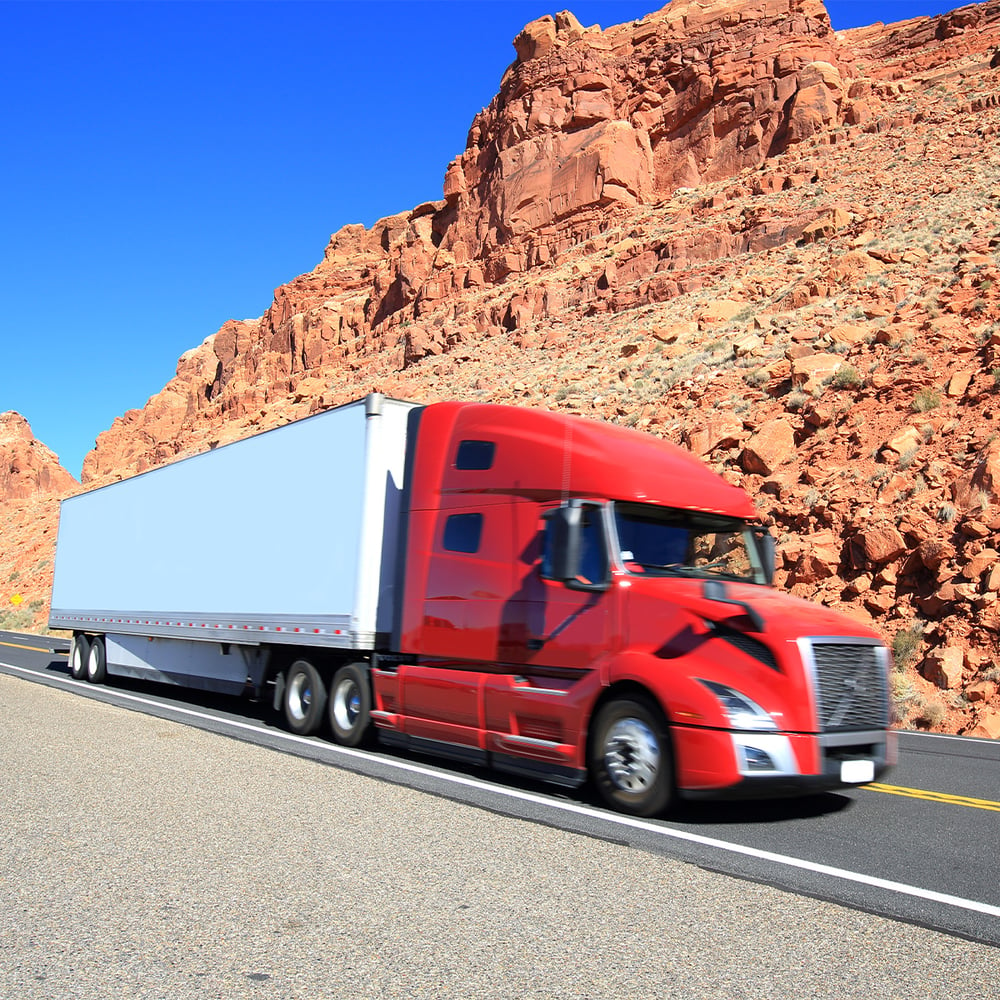 red-semi-truck-with-white-trailer-on-two-lane-desert-highway