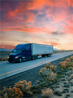 transportation-hero-rd2-semi truck driving down desert road at dusk